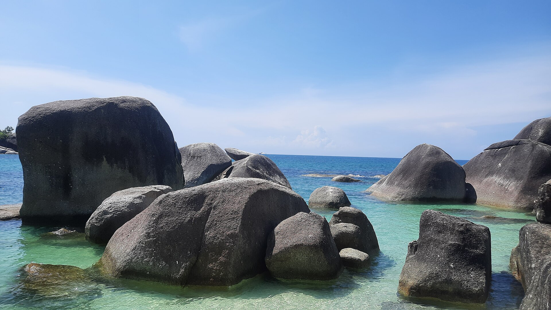 Giant granite boulders rising from turquoise shallows at Tanjung Tinggi Beach, Belitung