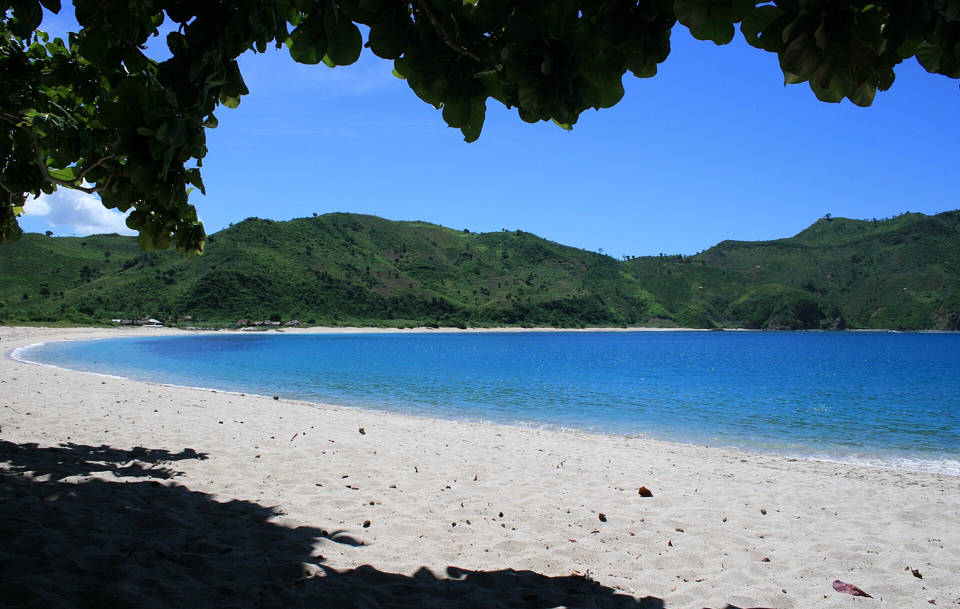 Empty turquoise horseshoe bay at Mawun Beach near Kuta, Lombok, on a bright day
